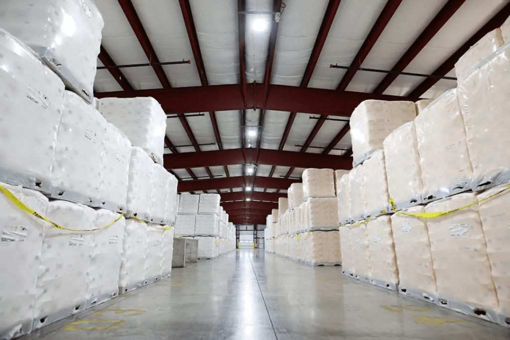Warehouse interior lined with neatly stacked pallets of goods, showcasing efficient space utilization and organization in inventory management.