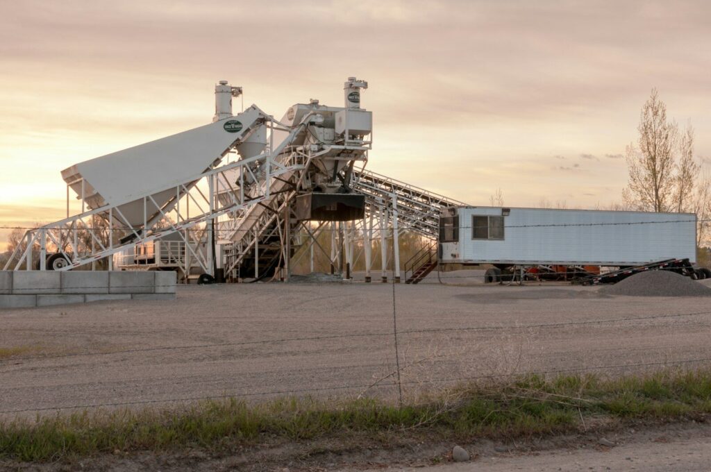 An industrial concrete plant against an evening sky.